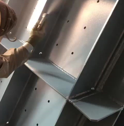 Profissional aplicando revestimento em estrutura de metal